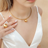 Close-up view of Casie Necklace's 18k gold-coated dome pendant.