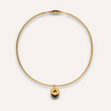 Casie Necklace in gold with bold dome pendant on snake chain, laid flat on white background.