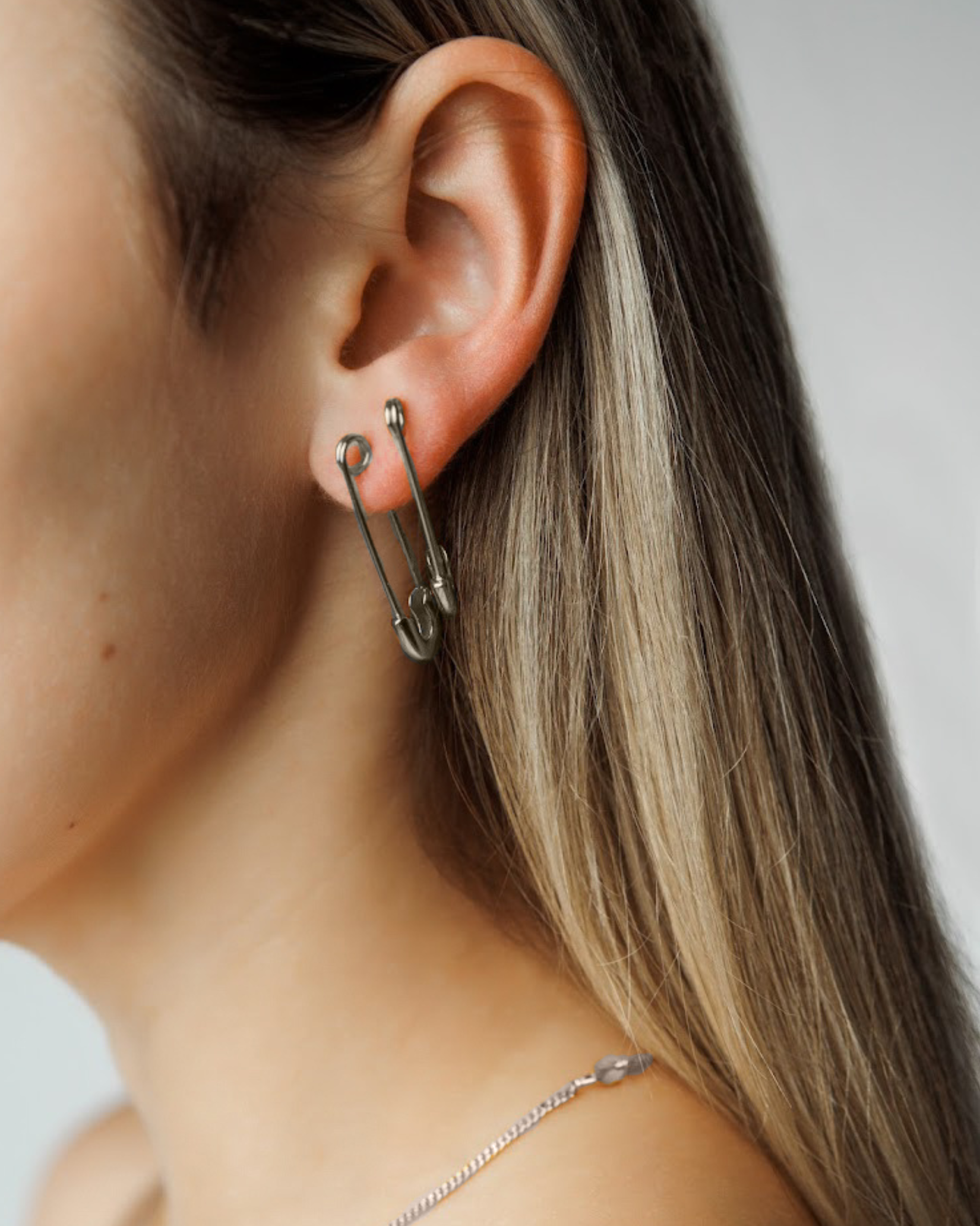 Side view of Gil Earrings in silver on a model, highlighting the sleek and edgy profile.
