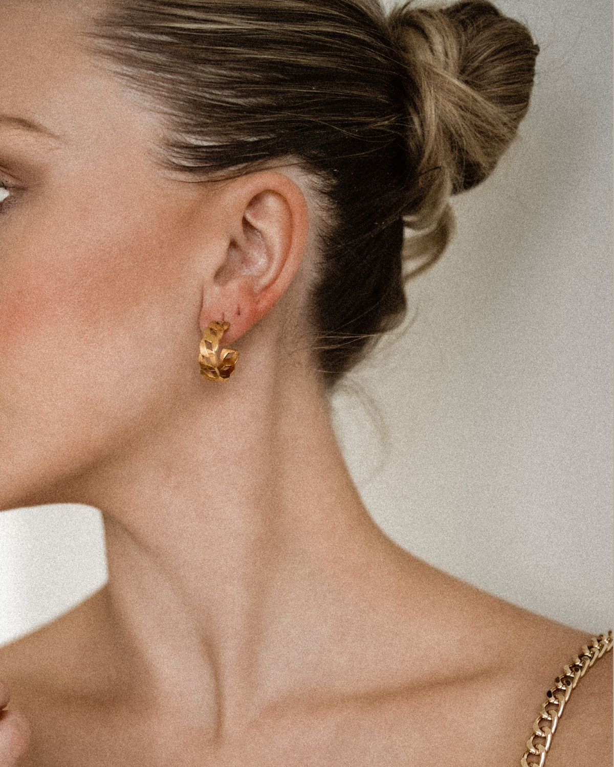 Side angle of Kalani Earrings worn, showing industrial-inspired huggie style.