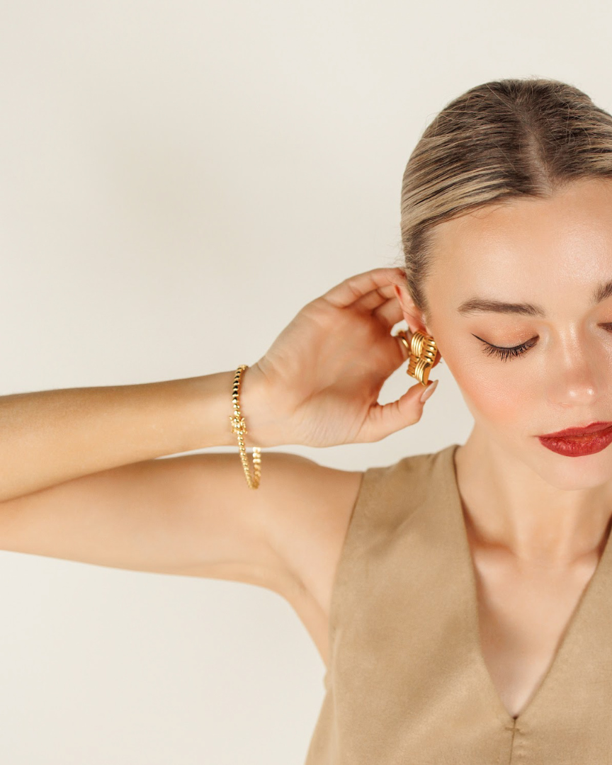 Model wearing the Love Bracelet alone, elevating an elegant long-sleeved outfit.