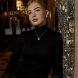 Half body shot of model wearing the Myrcella Necklace for a refined look.