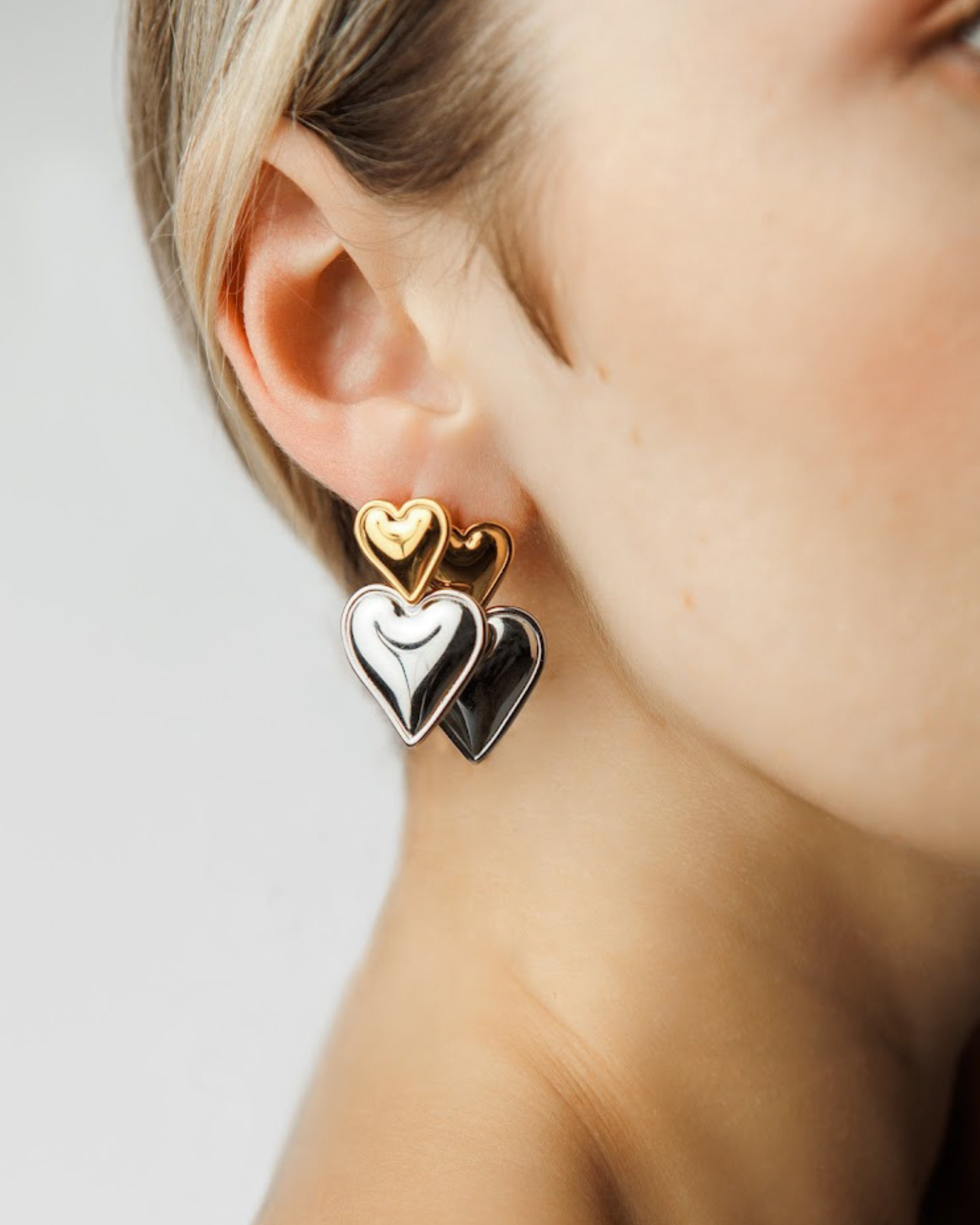 Profile view of Sadie Earrings with two-tone heart elements.