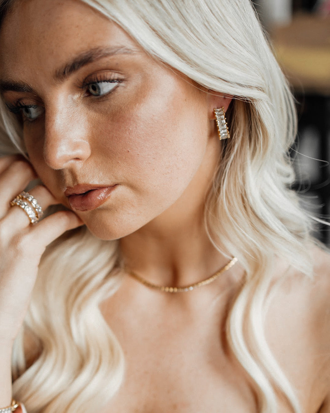 Side view of model wearing Ciana Earrings in gold and zirconia.