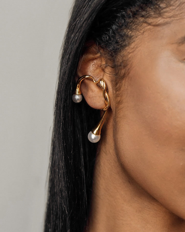 Closeup view of Dahlia Ear Cuff worn on ear showing pearl accents and branch design.