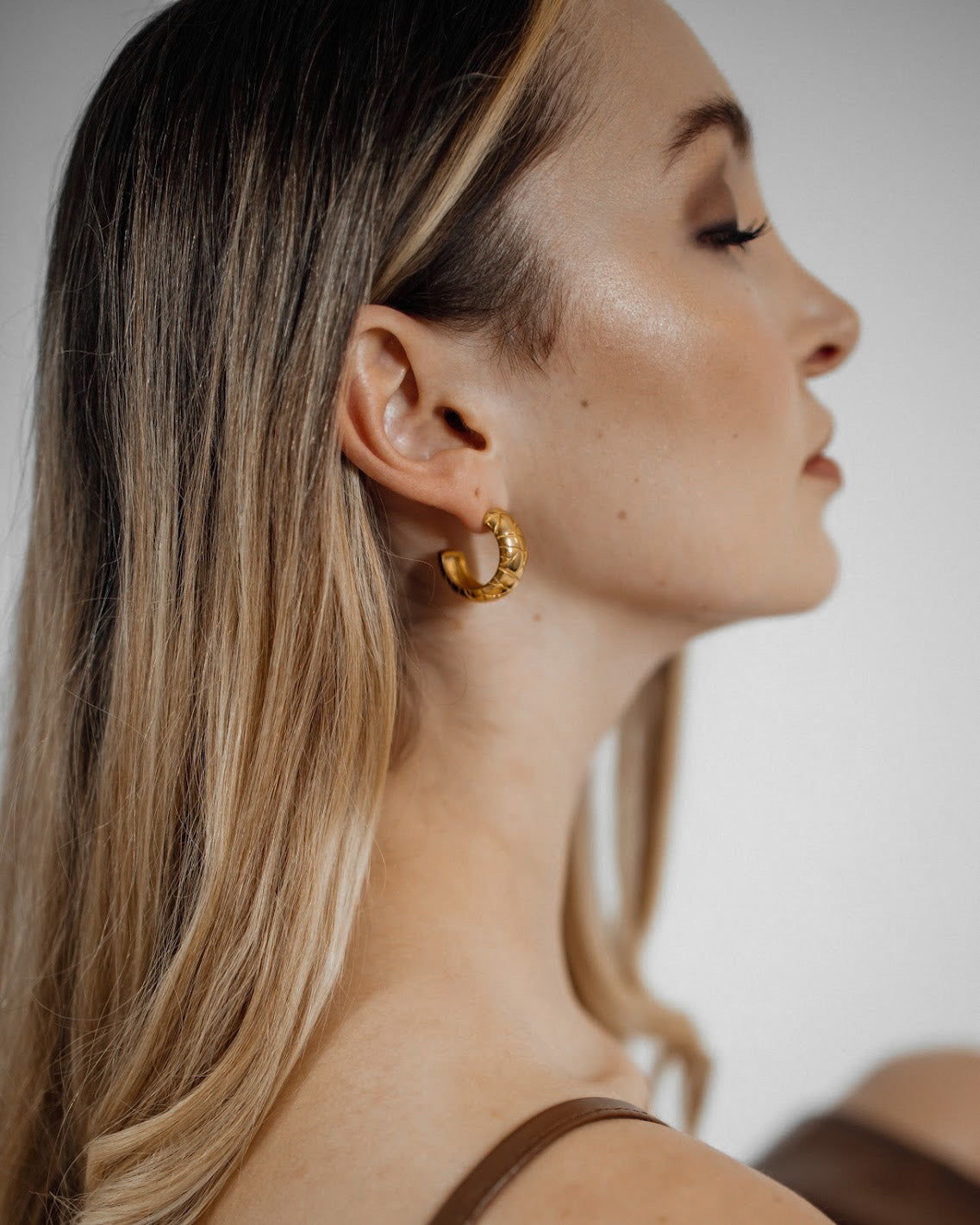 Worn Gaia Earrings shown from the side, capturing tropical chic elegance.