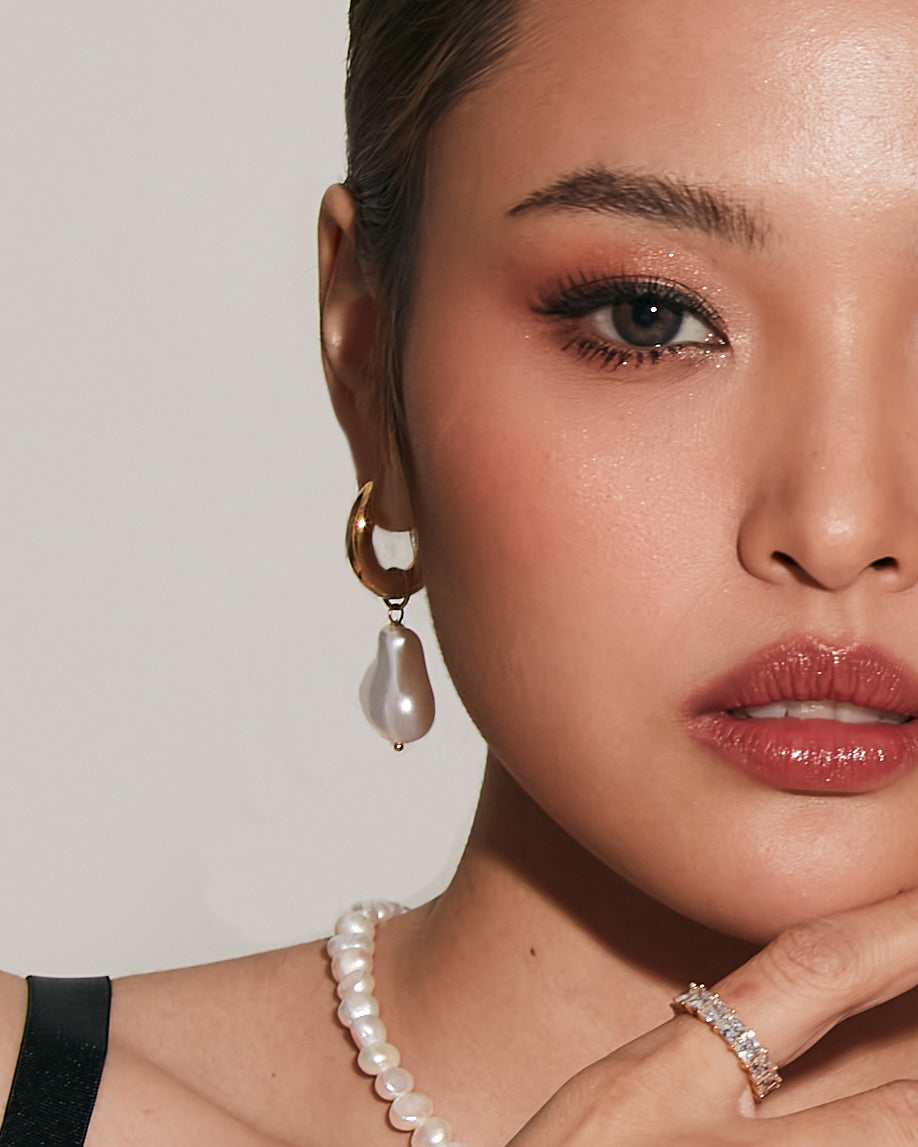 Half-face view of model wearing Maya Earrings with pearl attachment.