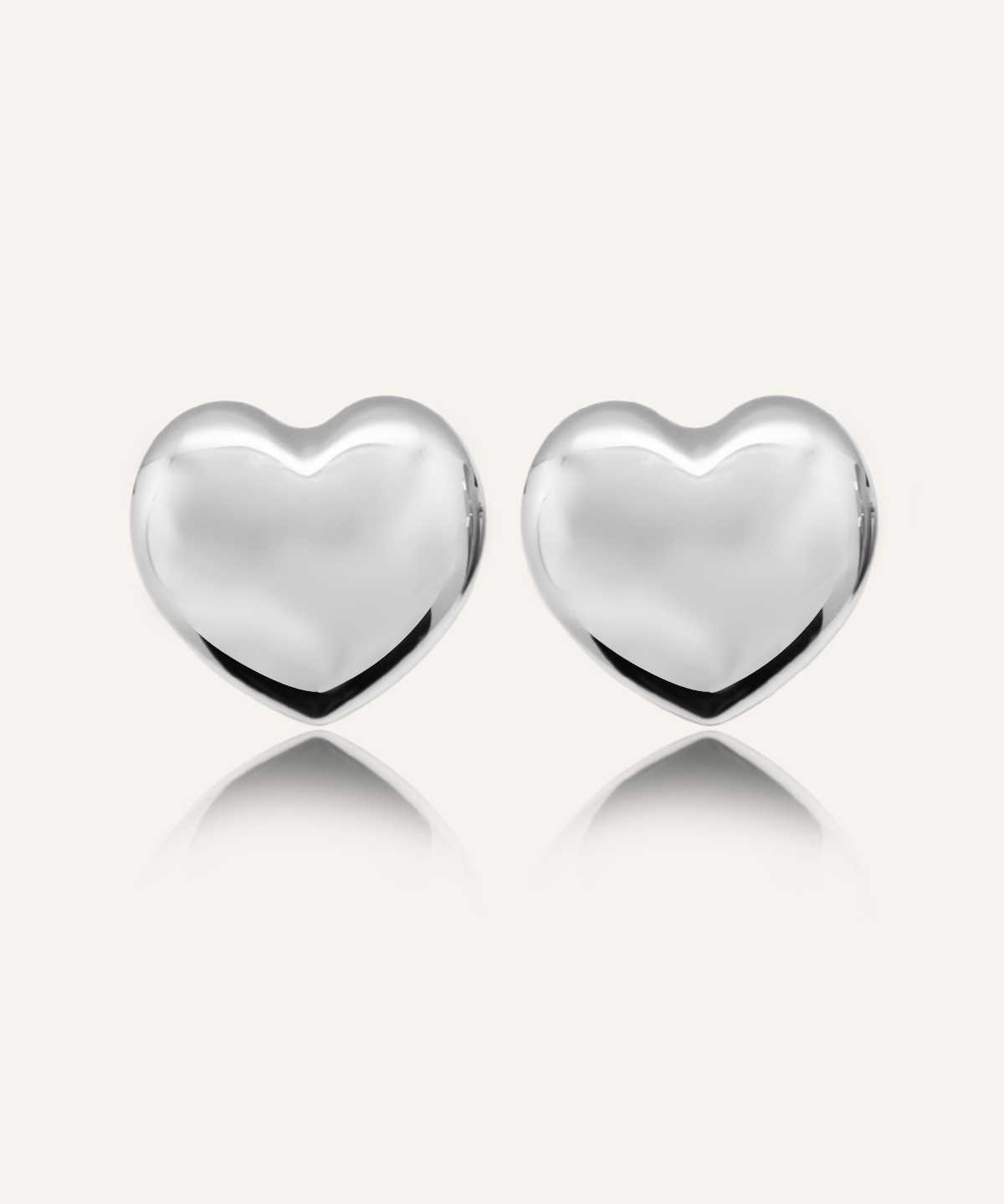 Adora Earrings in 18k silver displayed flat on beige background.