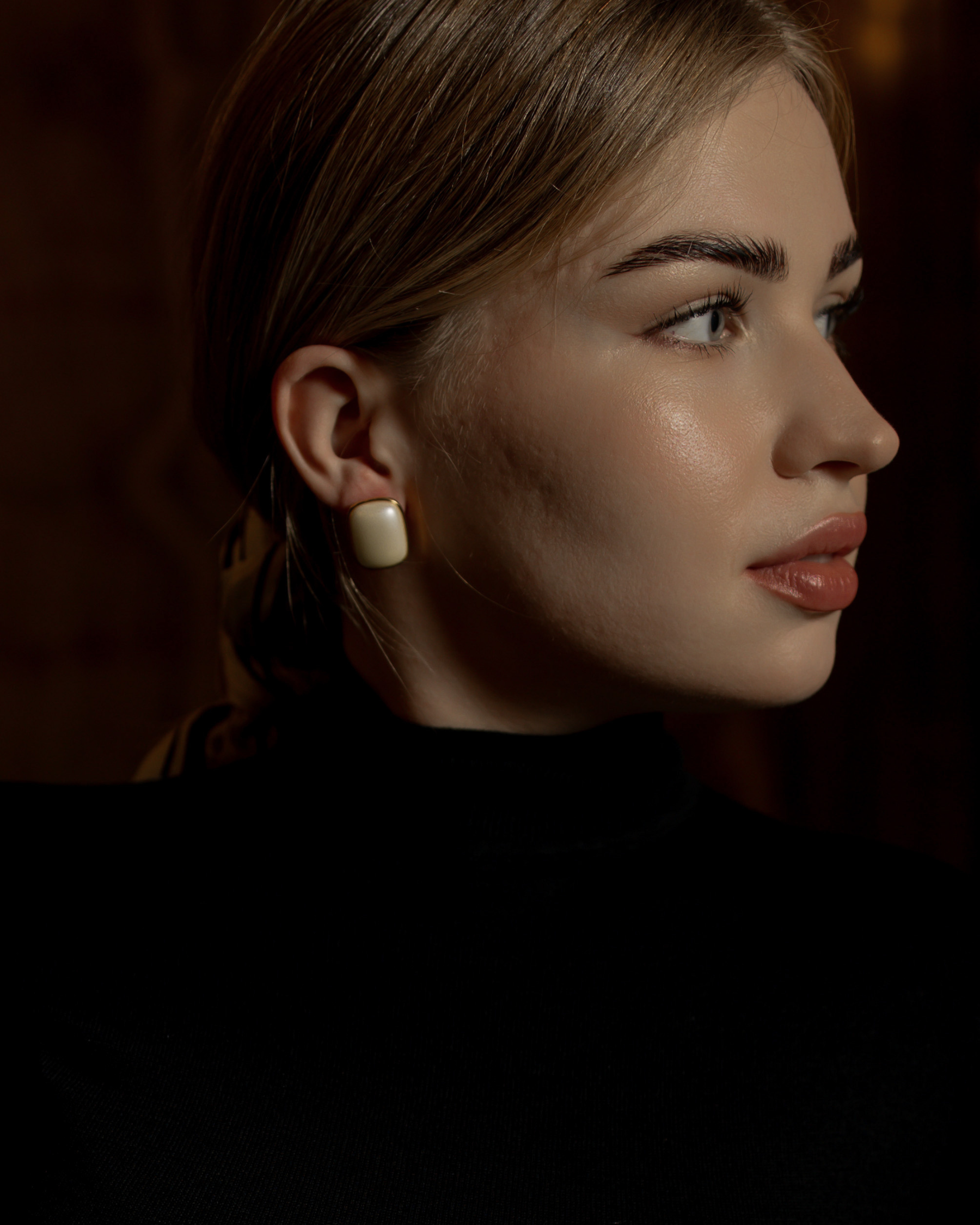 Close-up of Blaire Earrings worn, showcasing pearl detail and gold finish.