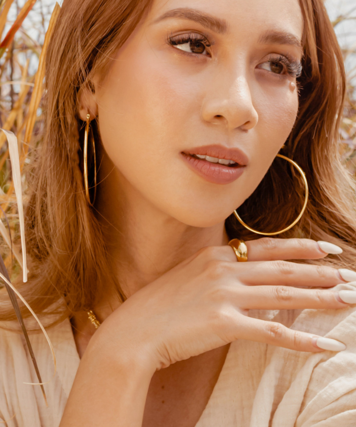 Closeup of Casia gold hoop earrings worn for a chic daily look.