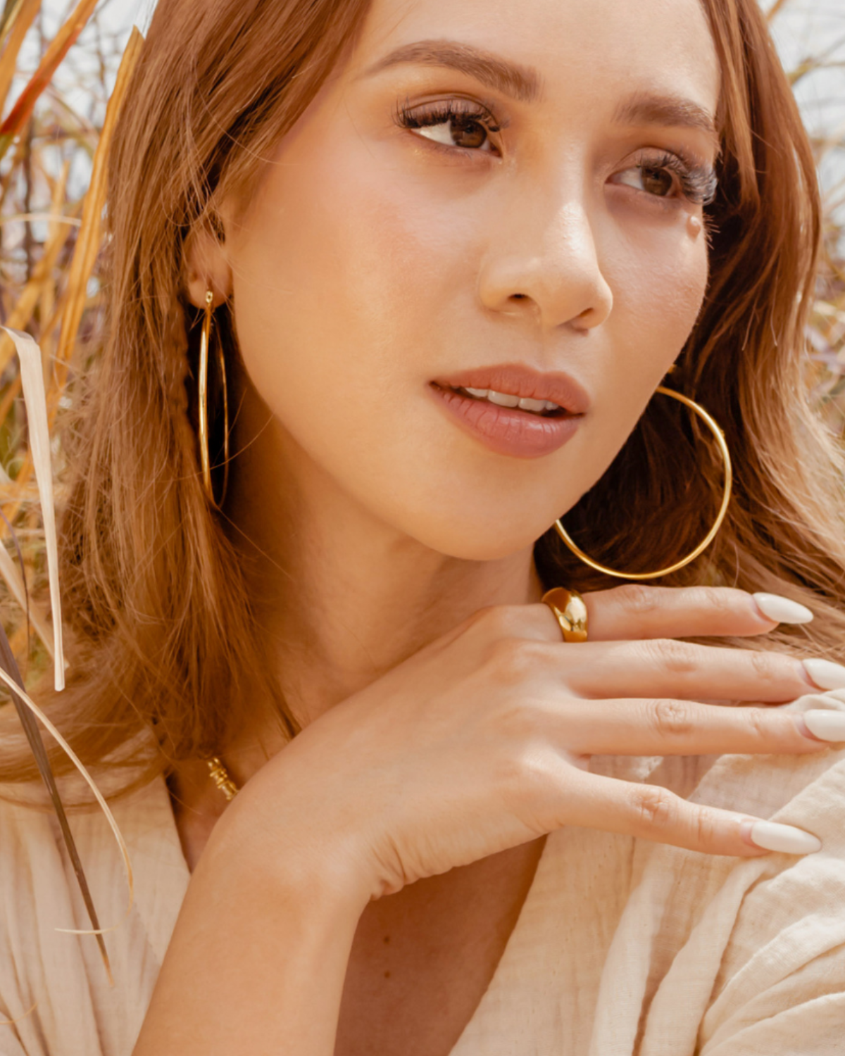 Closeup of Casia gold hoop earrings worn for a chic daily look.