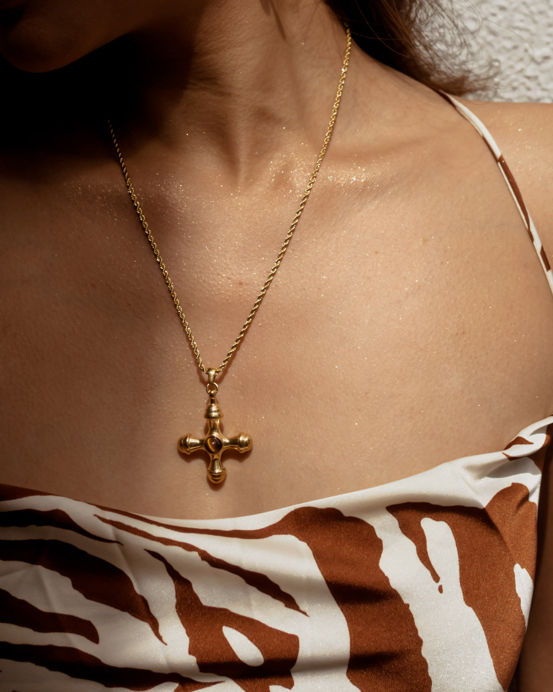 Closeup of model wearing Chiara Necklace with tiger eye cross pendant.