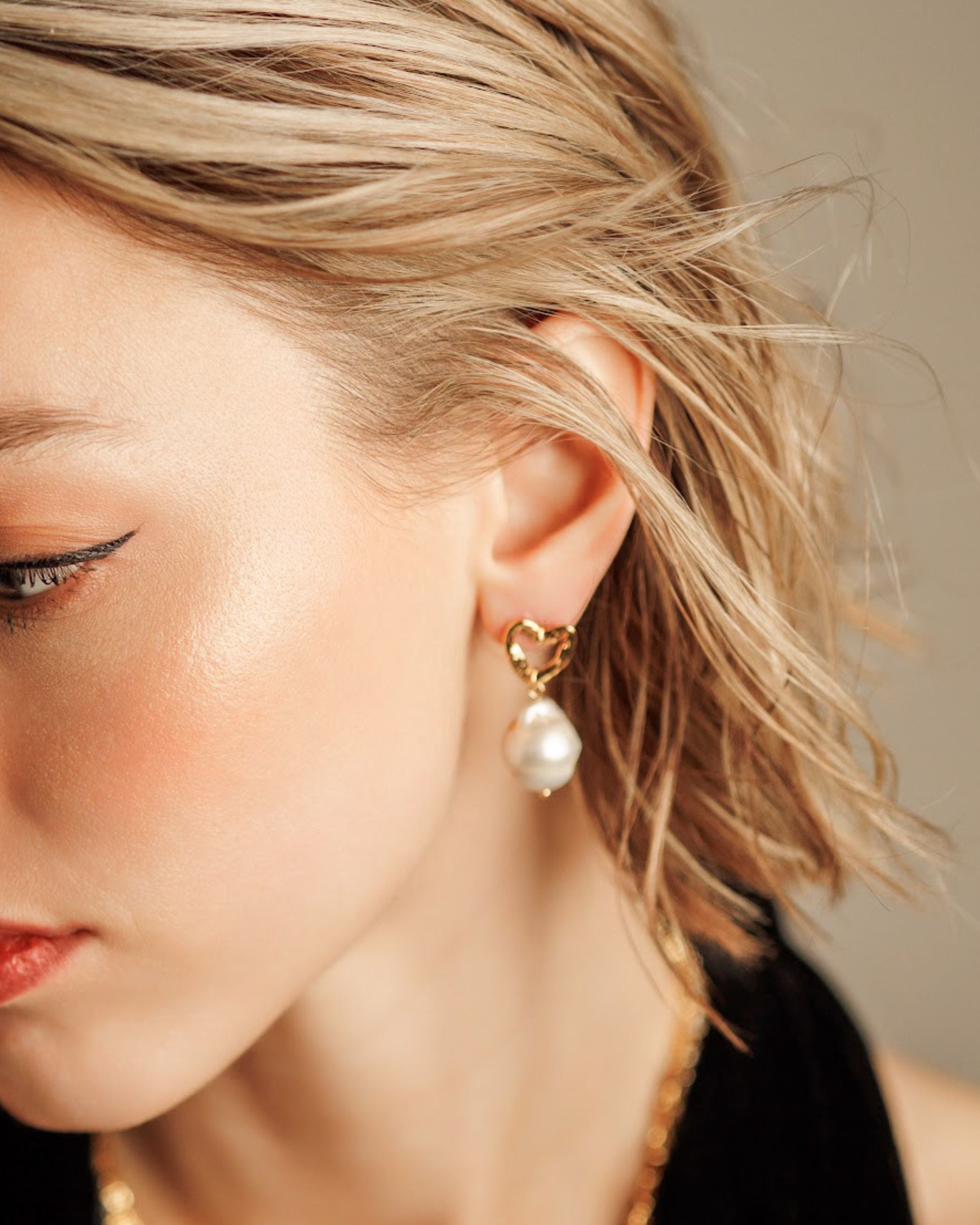 Close-up of Freya Earrings worn, showing baroque pearl and gold details.