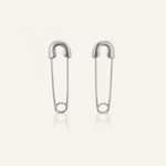Silver-coated Gil Earrings designed like a safety pin, laid flat to show unique clasp and edgy shape.