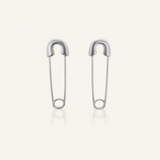 Silver-coated Gil Earrings designed like a safety pin, laid flat to show unique clasp and edgy shape.