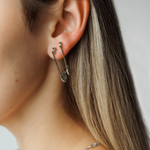 Side view of Gil Earrings in silver on a model, highlighting the sleek and edgy profile.