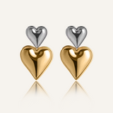 Giselle Earrings featuring gold and silver stacked heart drops with a polished finish.