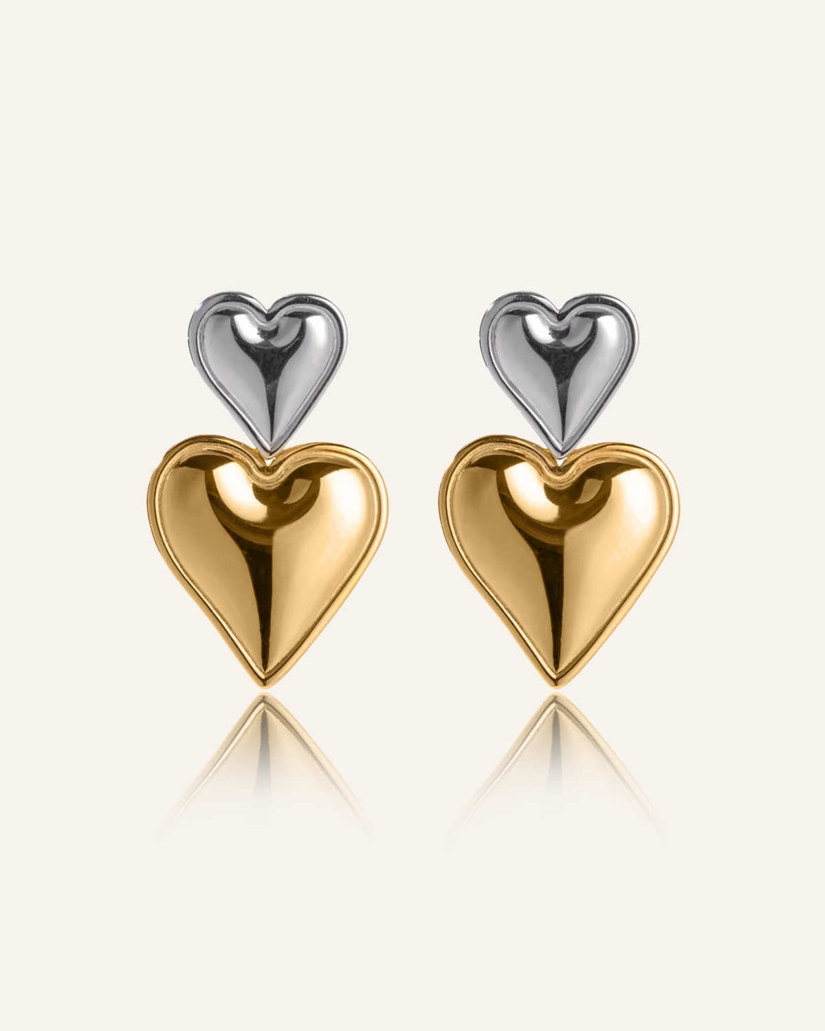 Giselle Earrings featuring gold and silver stacked heart drops with a polished finish.