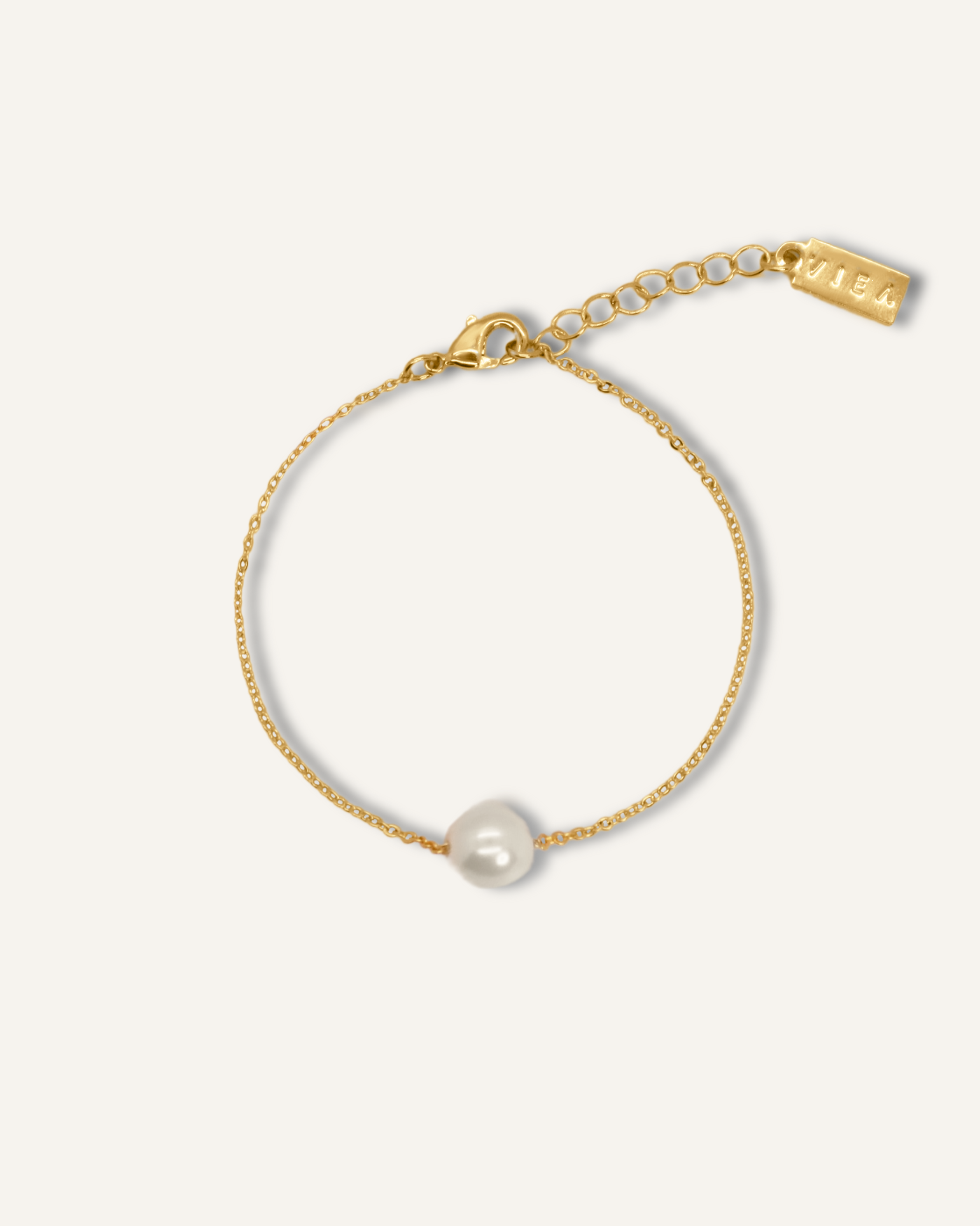Ina Bracelet with gold chain and single pearl centerpiece.
