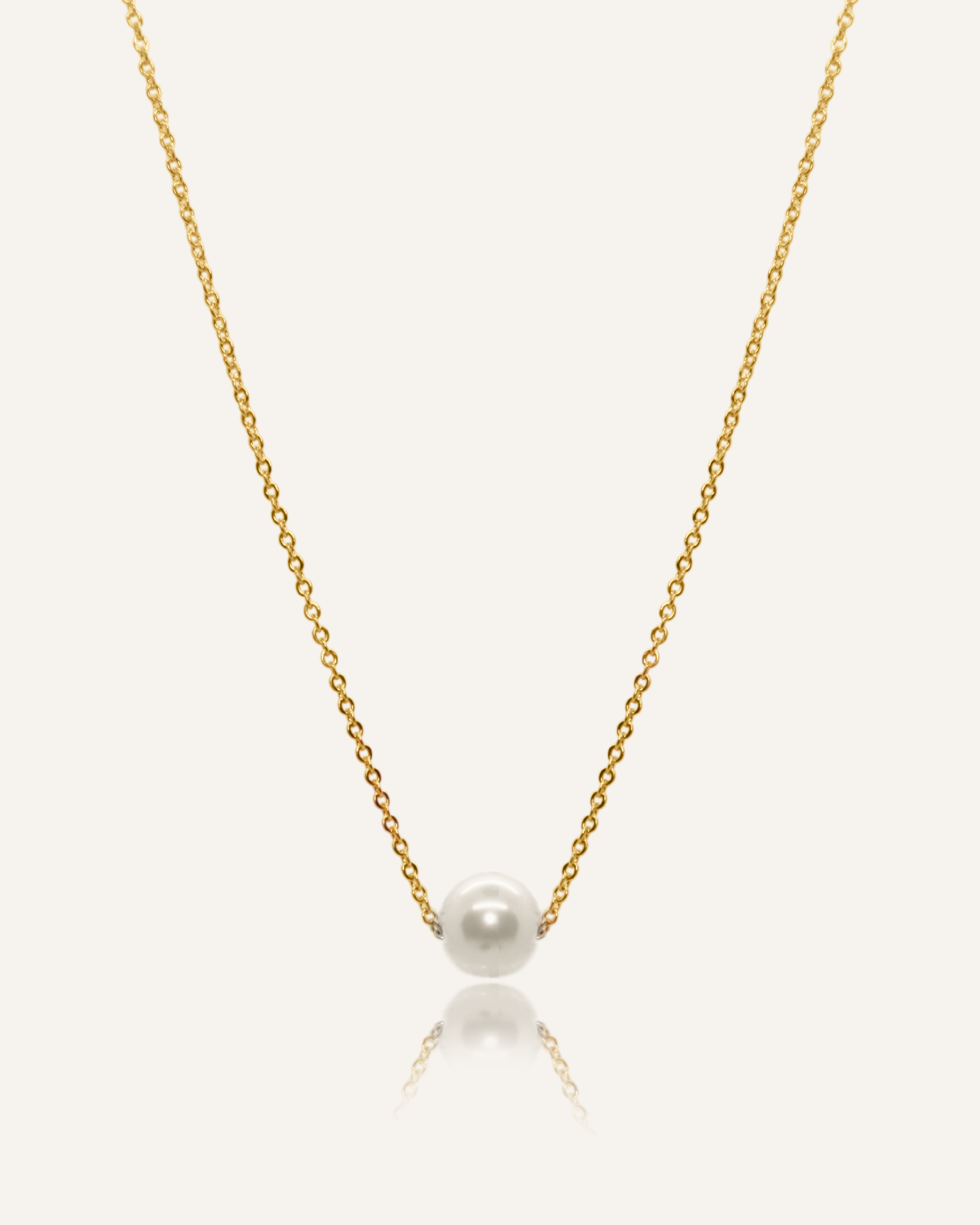 Ina Necklace featuring a gold chain with a single pearl pendant.