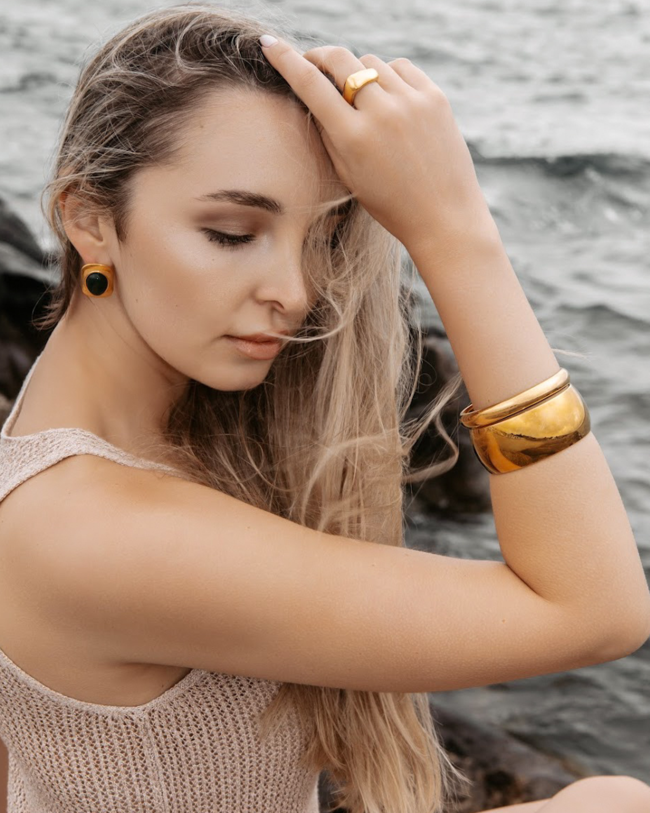 Woman wearing the Indie Gold Cuff with a light brown top, showcasing its bold yet minimal design.