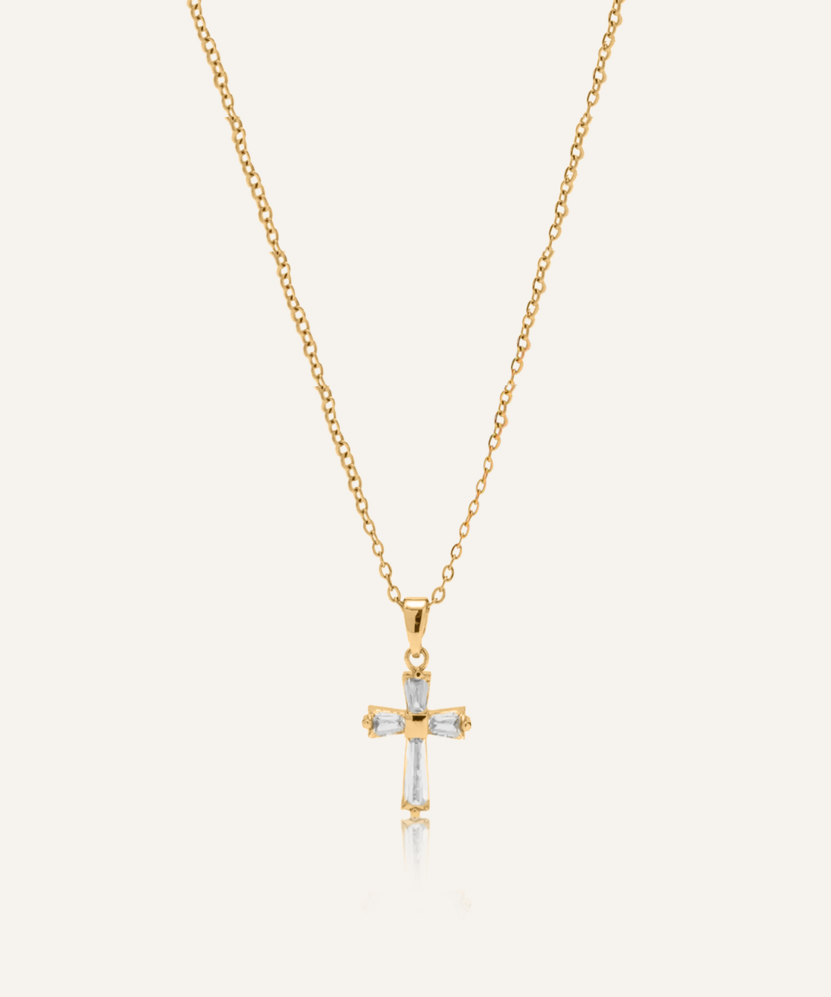 Flatlay of Iris Necklace featuring gold chain and cross pendant with zirconia stones.