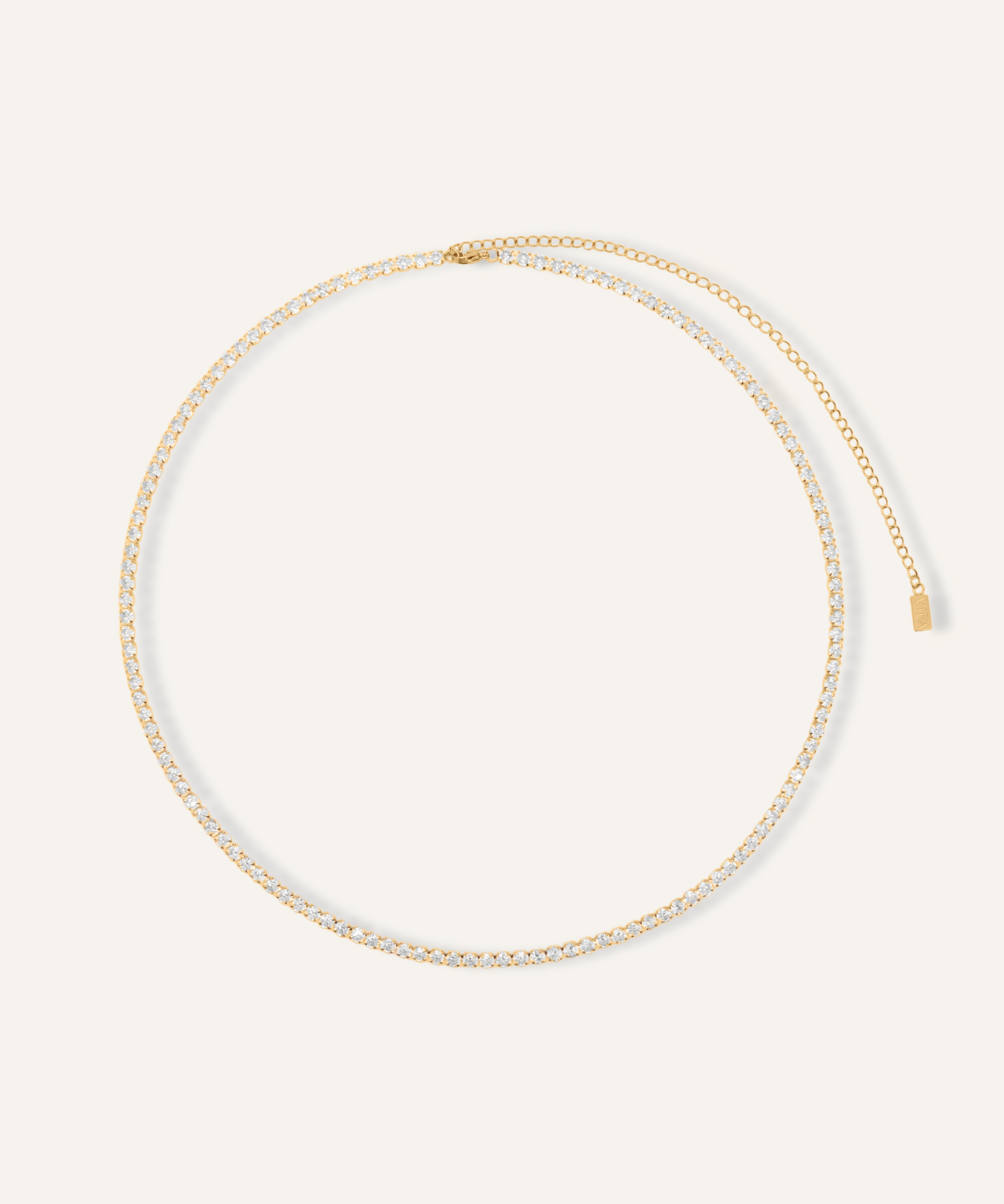 Flatlay image of the Isabel Body Chain featuring a gold tennis chain with cubic zirconia.