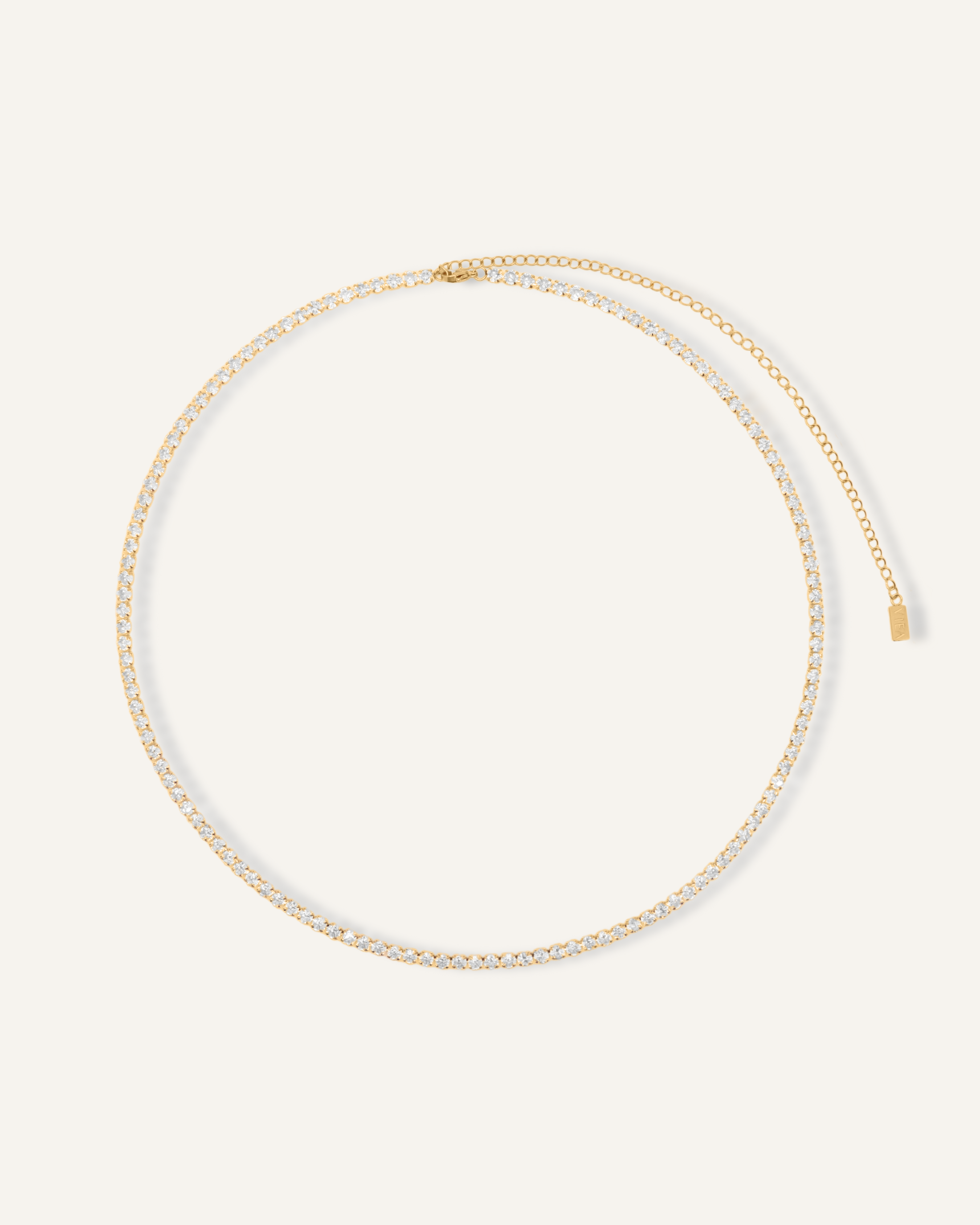 Flatlay image of the Isabel Body Chain featuring a gold tennis chain with cubic zirconia.