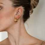 Side angle of Kalani Earrings worn, showing industrial-inspired huggie style.