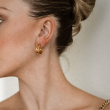 Side angle of Kalani Earrings worn, showing industrial-inspired huggie style.