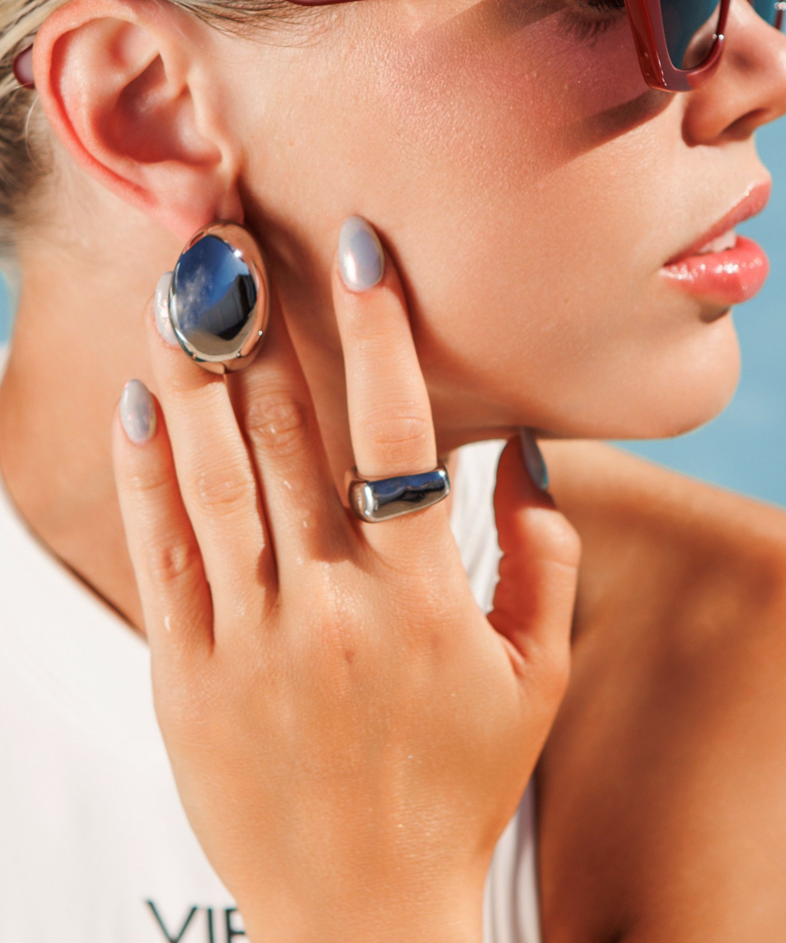 Close-up of silver Kyma Ring with irregular edges worn on hand.