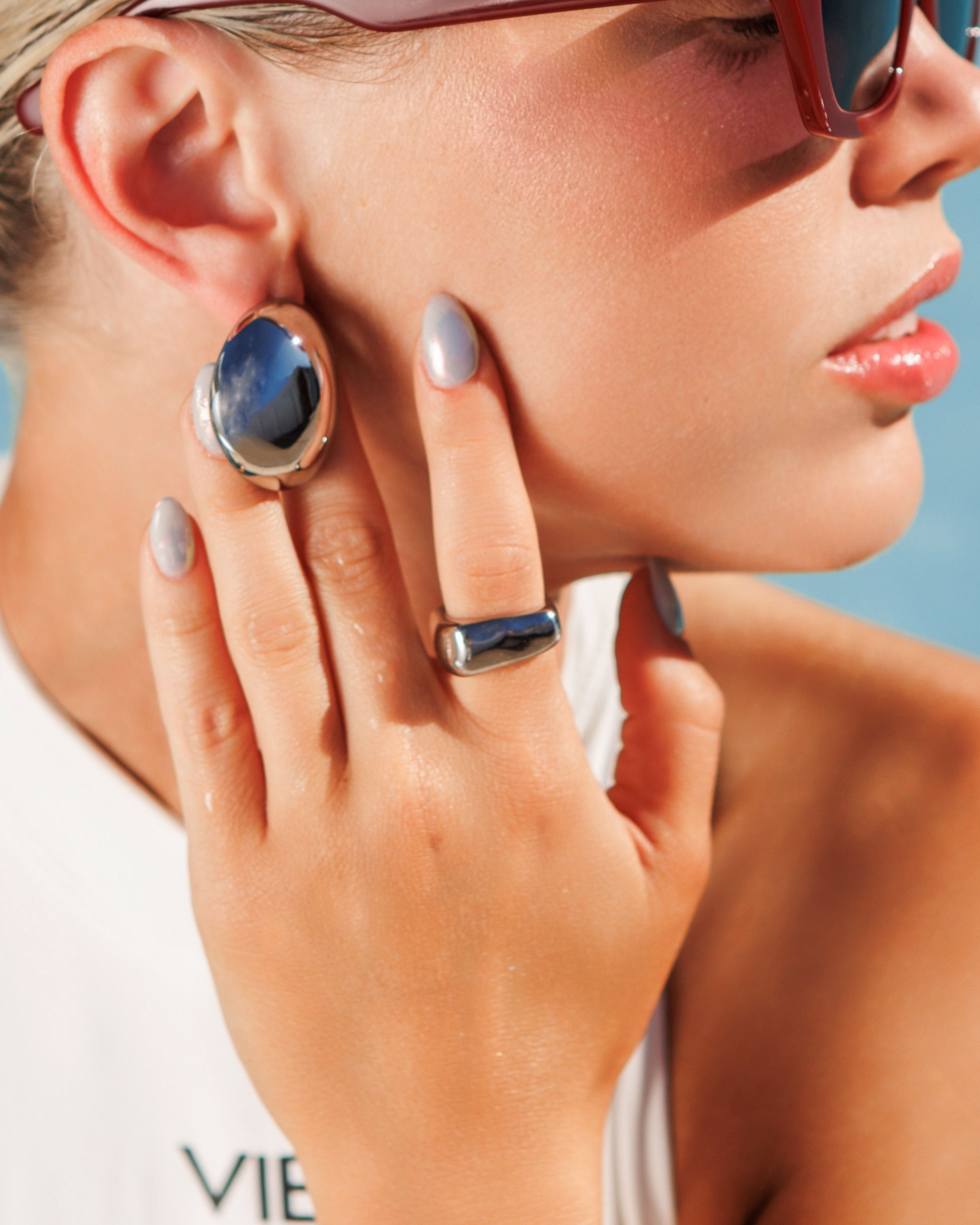 Close-up of silver Kyma Ring with irregular edges worn on hand.