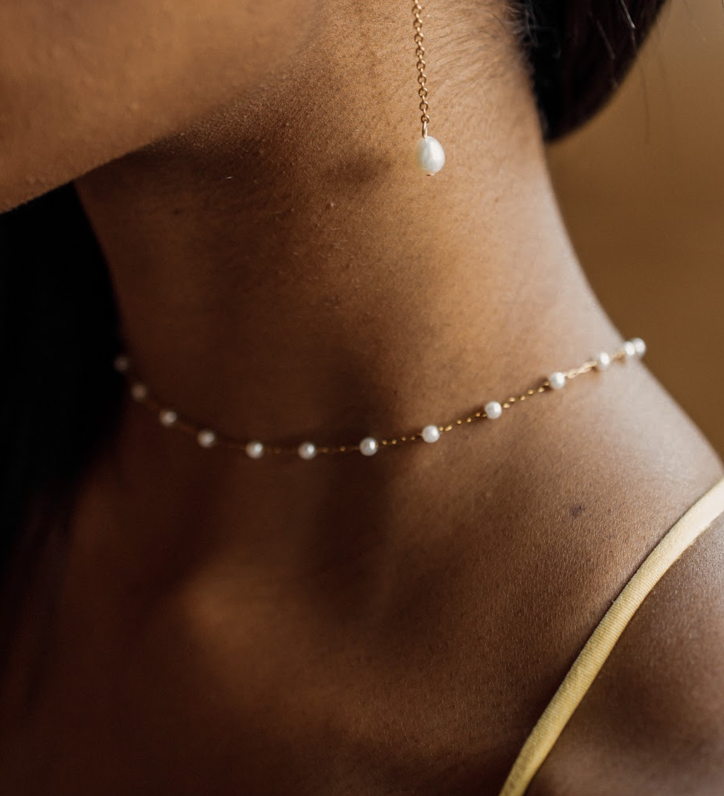 Closeup of the Layla Necklace worn, highlighting pearl and gold link pattern.