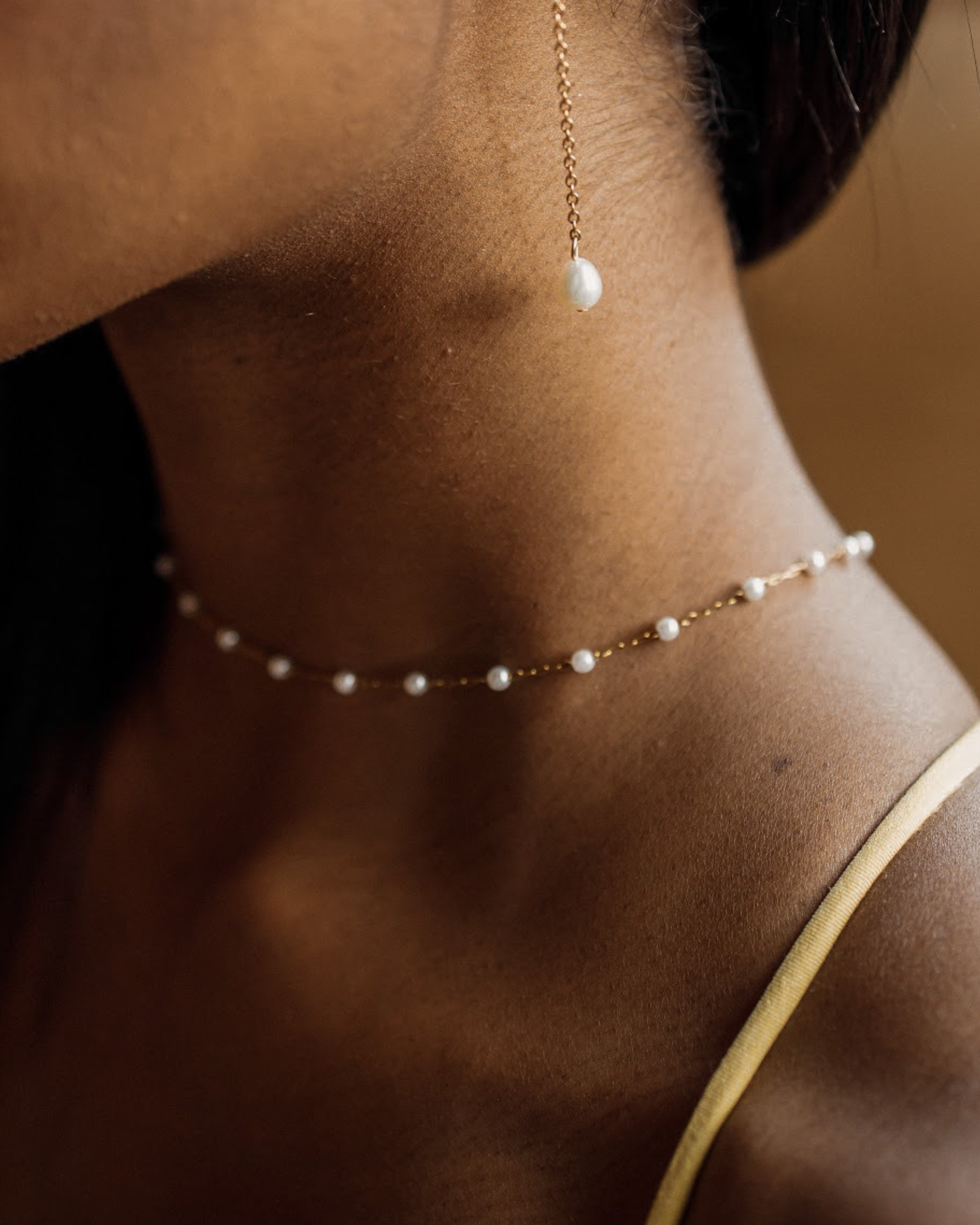 Closeup of the Layla Necklace worn, highlighting pearl and gold link pattern.