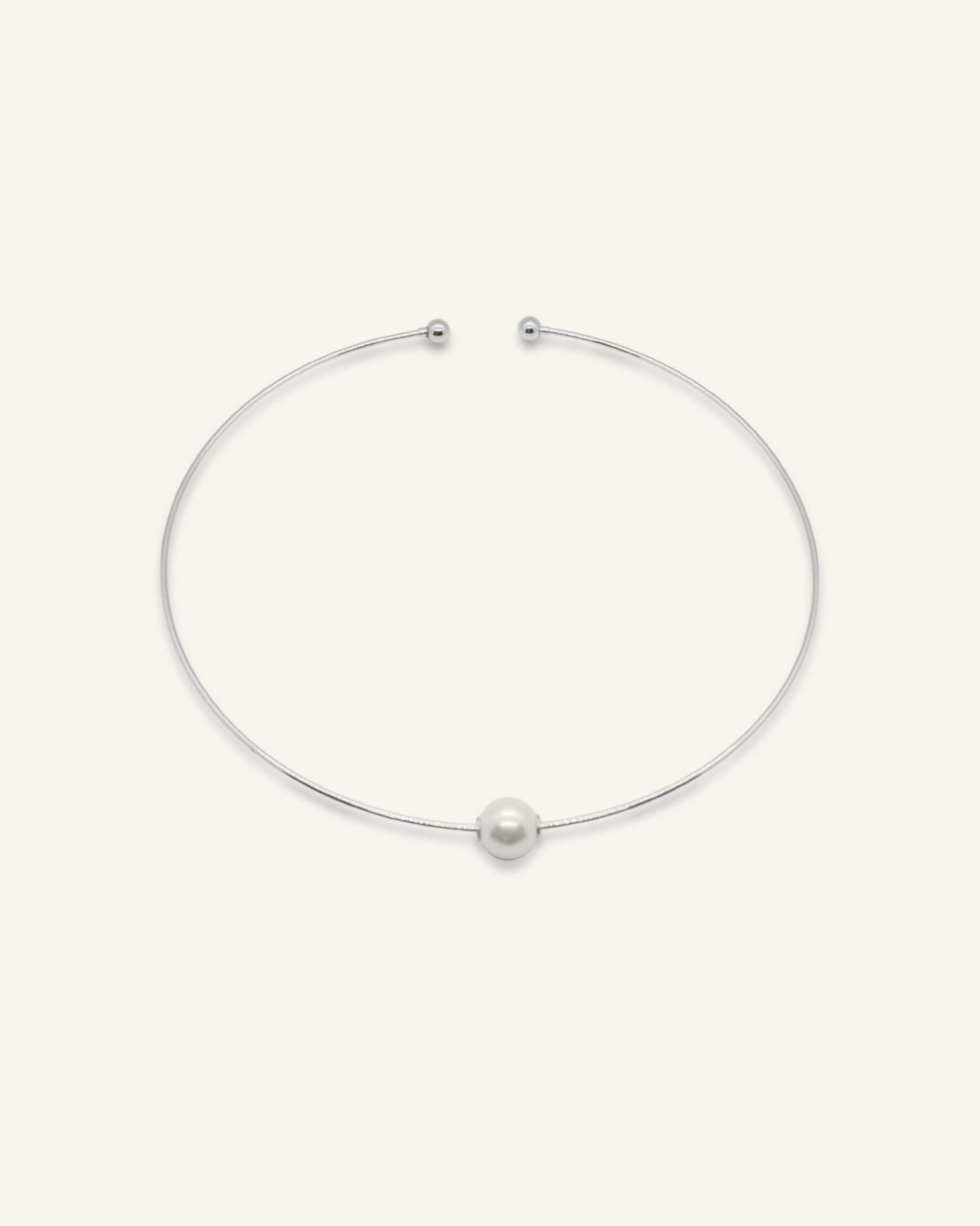 Silver-coated Loreli Choker with central pearl and paperclip chain design, laid flat to highlight details.