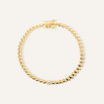 Flatlay of Love Bracelet showcasing 18K gold heart-shaped chain with central cubic zirconia stone.
