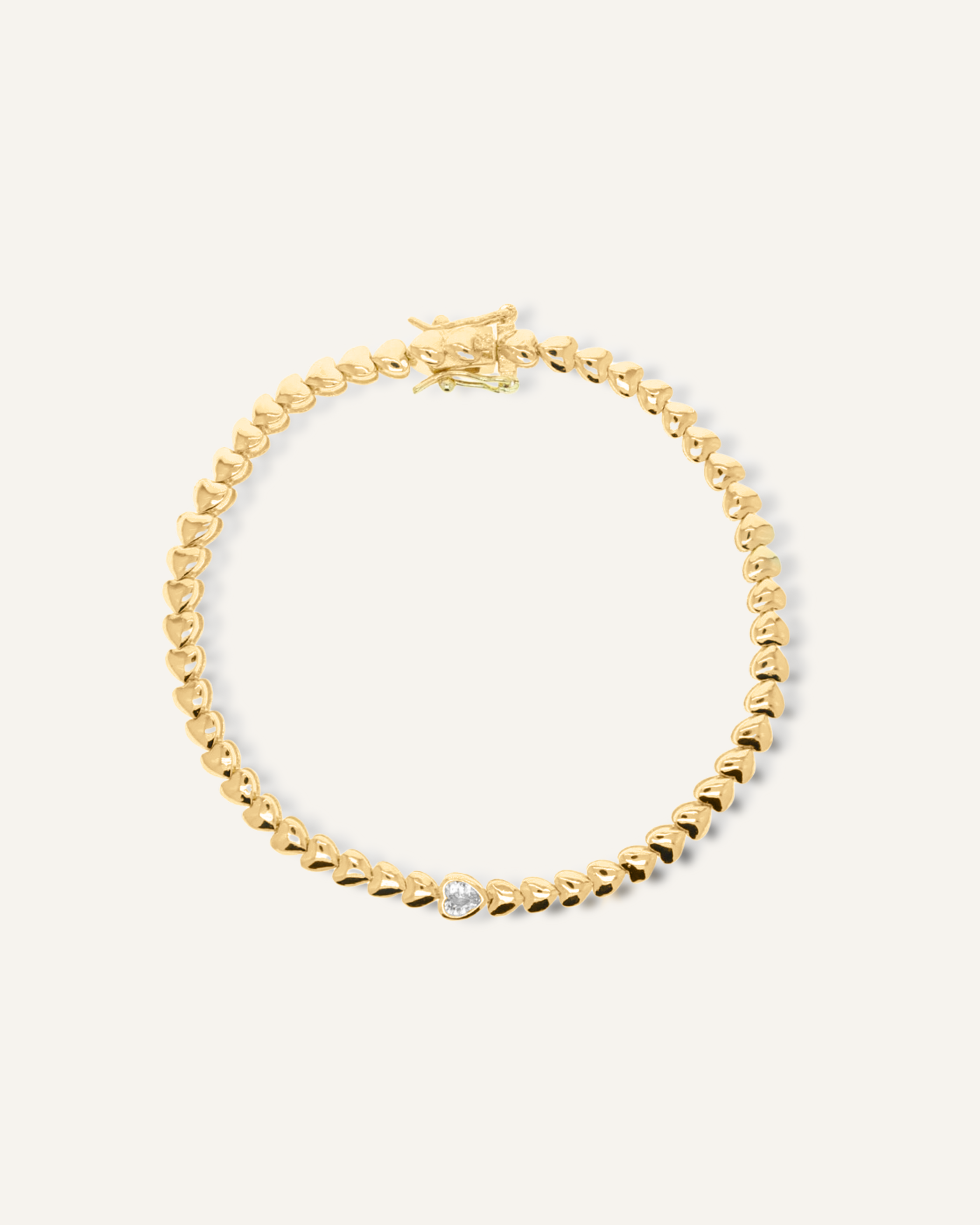Flatlay of Love Bracelet showcasing 18K gold heart-shaped chain with central cubic zirconia stone.