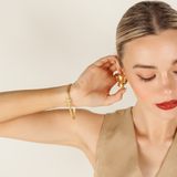 Model wearing the Love Bracelet alone, elevating an elegant long-sleeved outfit.
