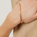 Close-up of Love Bracelet worn on wrist, highlighting its heart-shaped links and bold gold finish.