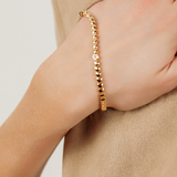 Close-up of Love Bracelet worn on wrist, highlighting its heart-shaped links and bold gold finish.