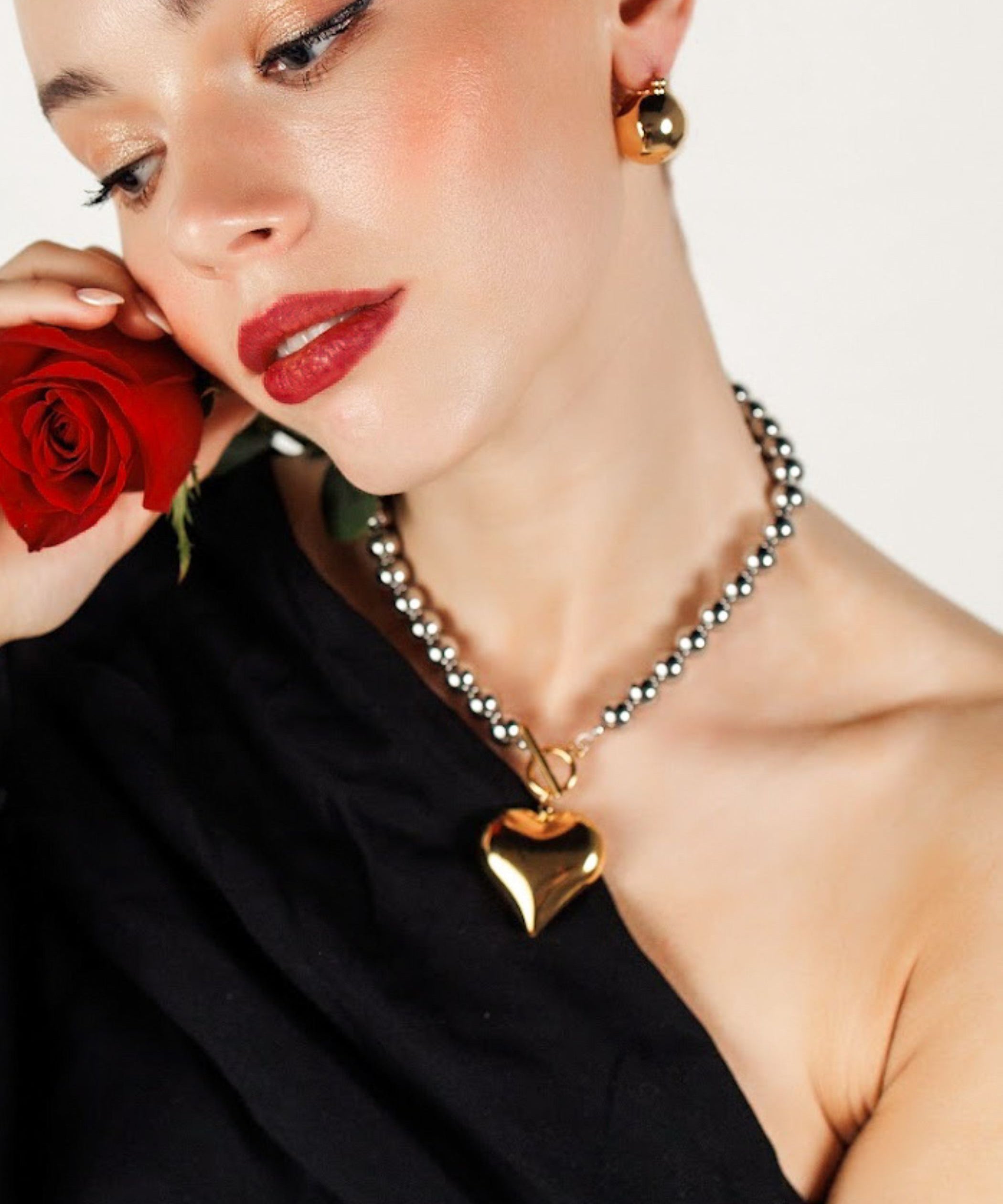 Close-up of the Margaux Necklace gold heart pendant and toggle clasp detail.