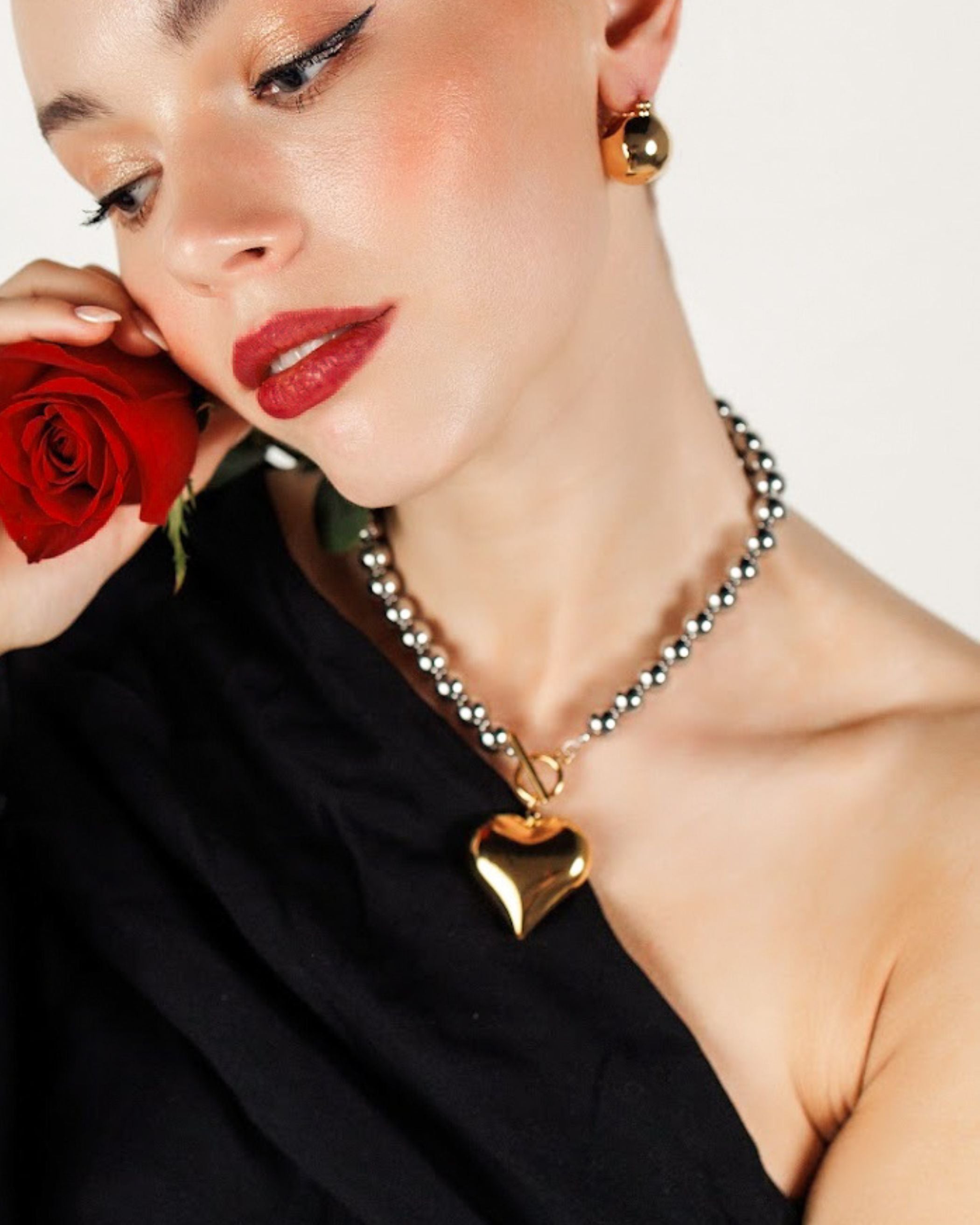 Close-up of the Margaux Necklace gold heart pendant and toggle clasp detail.