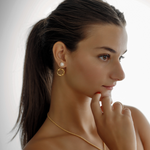 Model styling Maria Earrings with visible hoop and pearl drop.