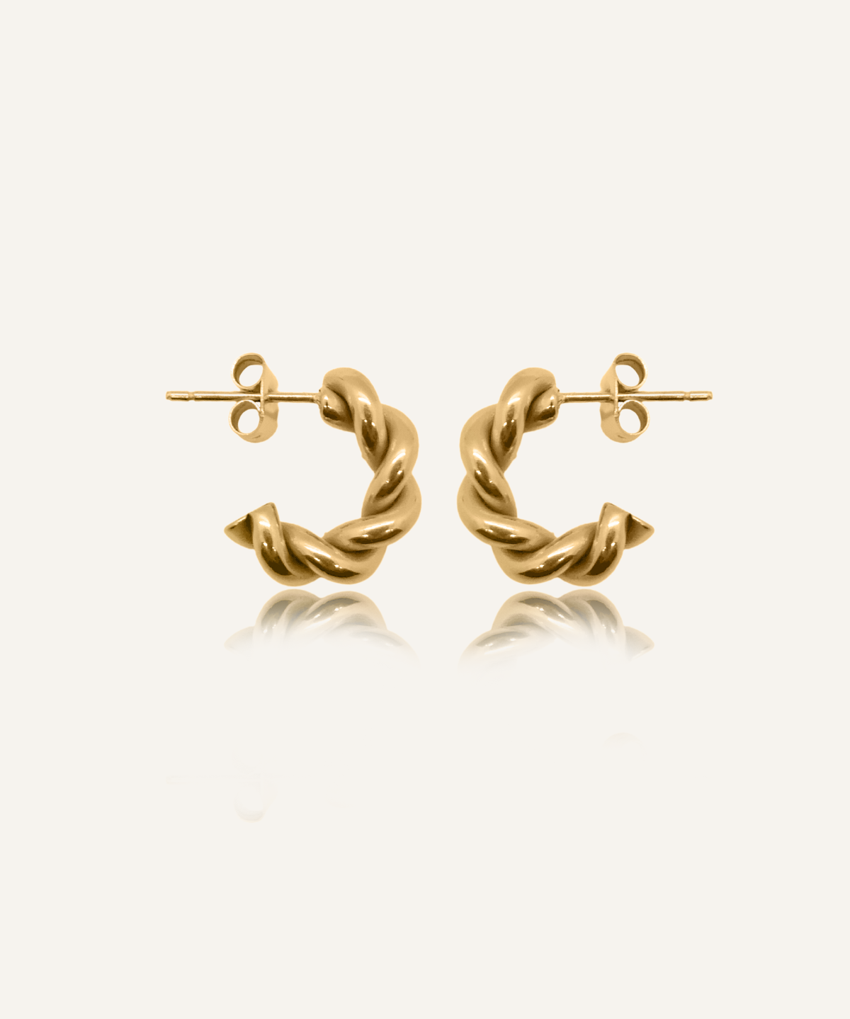 Flatlay of Mini Celeste Earrings in 18k gold, showcasing their twisted rope design and semi-hoop shape.