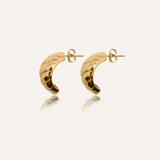 Flatlay of Mini Demi Earrings in 18k gold with croissant-inspired shape and glossy finish.