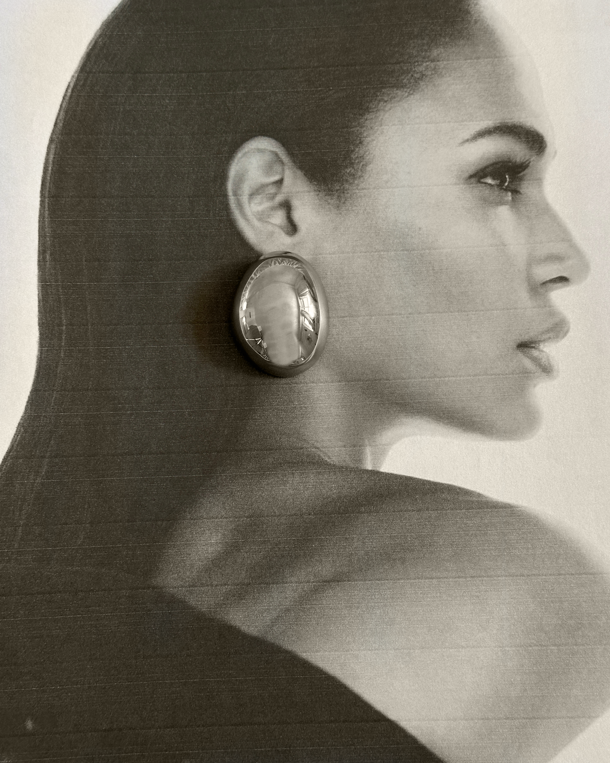 Model wearing Mona Silver Earrings showcasing their oval dome silhouette.