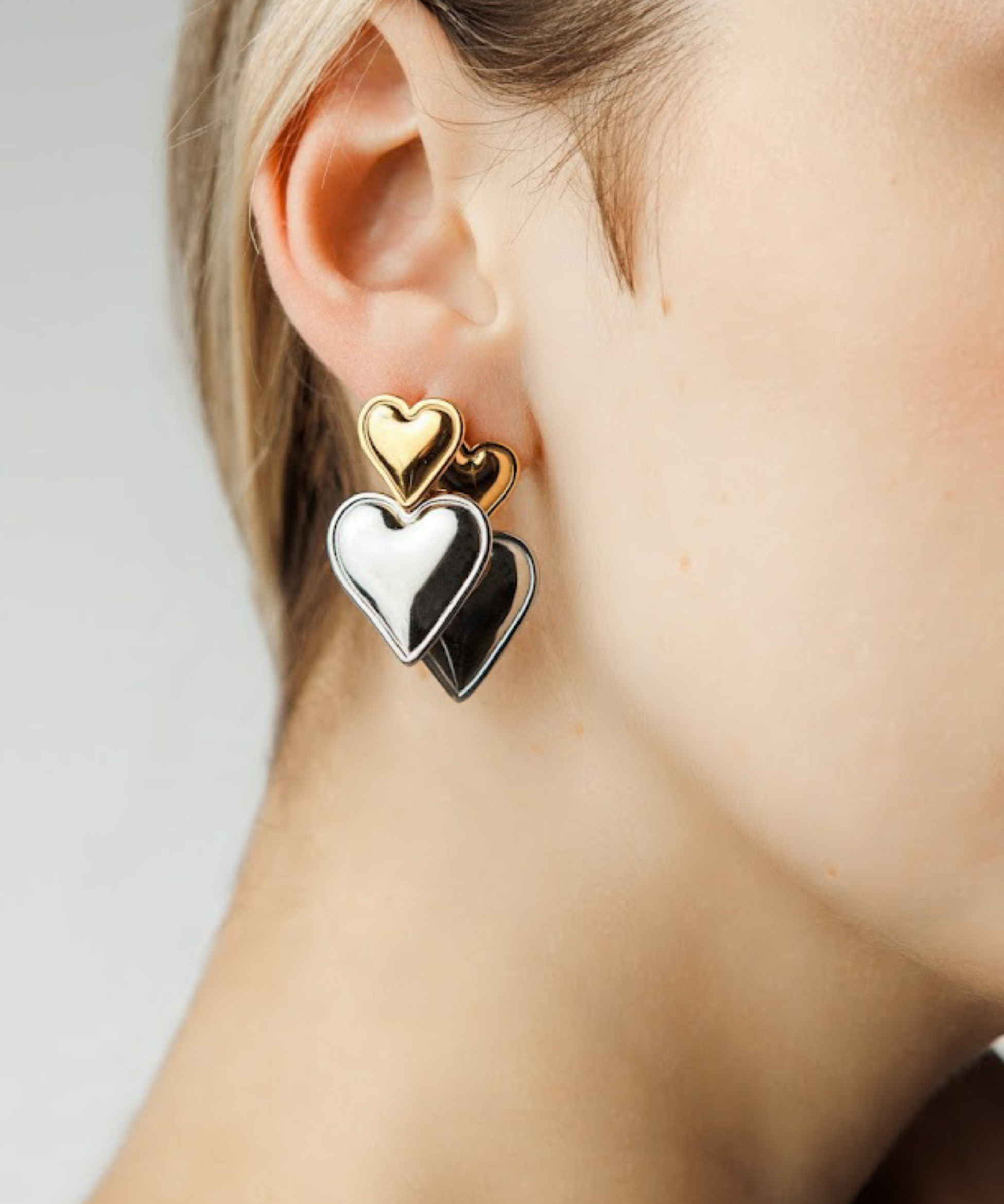 Close-up of Sadie Earrings showing gold heart atop silver heart detail.