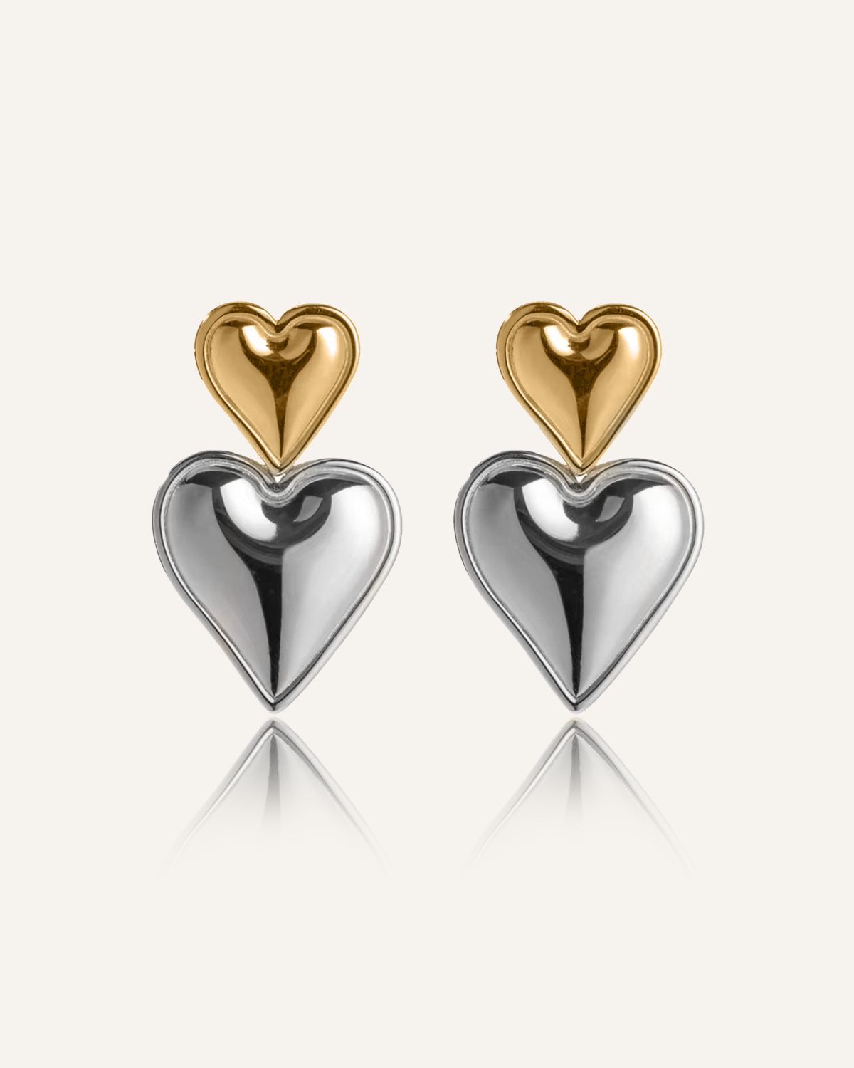 Sadie Earrings with stacked heart design in gold and silver on white background.