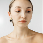 Front view of model wearing Sadie Earrings featuring gold and silver heart drops.