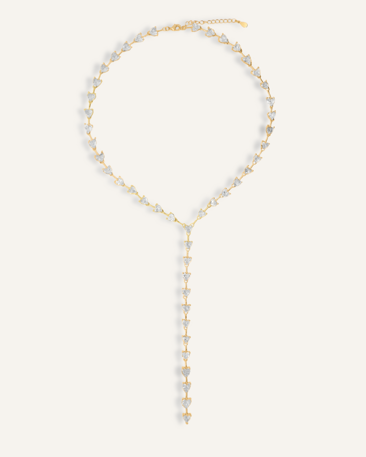 Flatlay of Seraphine Necklace in gold with heart-shaped zirconia charm and Y-drop design.